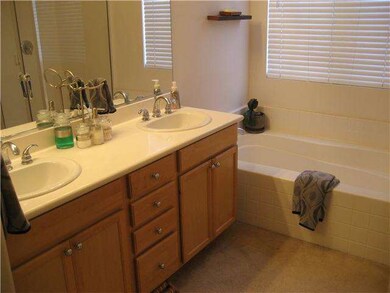 Master Bathroom with dual sinks, large bath tub, a