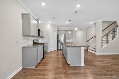 Kitchen featuring gray cabinets, stainless steel appliances, crown molding, backsplash, and recessed lighting