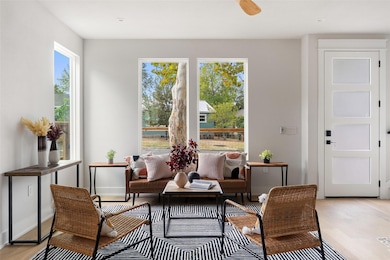 Sitting room featuring light wood-style flooring and ceiling fan