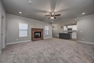 Unfurnished living room with carpet floors, healthy amount of natural light, ceiling fan, and recessed lighting