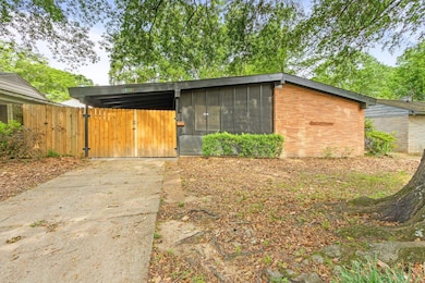 View of outdoor structure with a sunroom and a gate