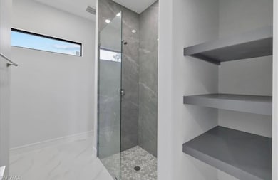 Full bathroom with marble finish floors and tiled shower