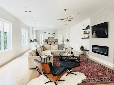 Living room with light wood finished floors, a fireplace, and recessed lighting