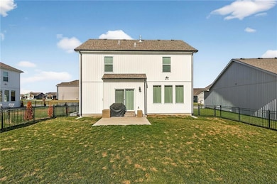 Back of house with a patio, roof with shingles, and a fenced backyard