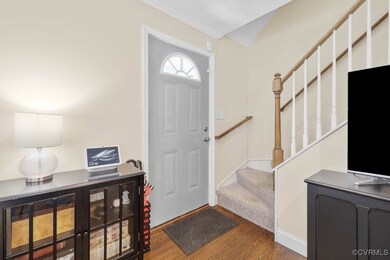 Entryway with wood finished floors, stairs, and ba
