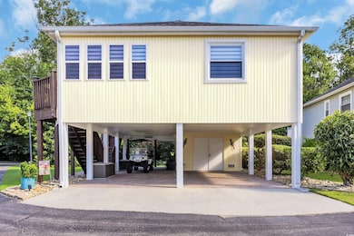 Coastal inspired home featuring a carport, stairway, and driveway