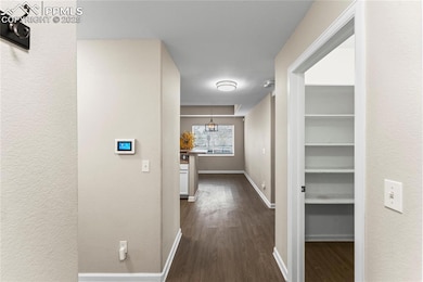 Hall featuring baseboards and dark wood finished floors