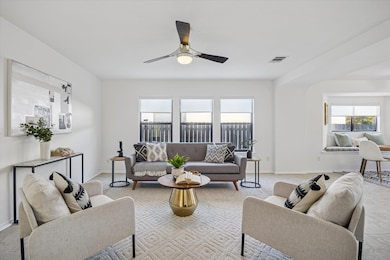 Living area with a ceiling fan and carpet floors