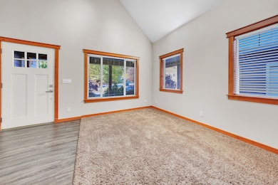 Entrance foyer with high vaulted ceiling and light wood-type flooring