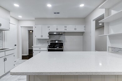 Kitchen with white cabinetry, Quartz countertops, 