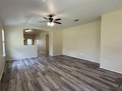 Empty room with arched walkways, a ceiling fan, d