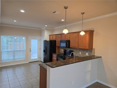Kitchen featuring black appliances, crown molding,