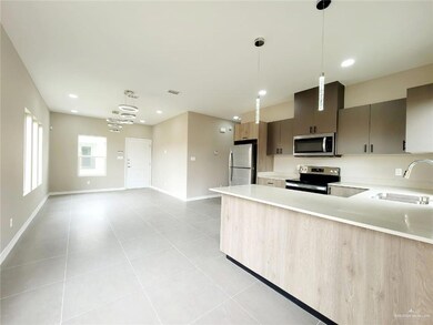 Kitchen featuring light countertops, stainless steel appliances, light tile patterned floors, decorative light fixtures, and recessed lighting