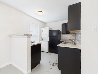 Kitchen featuring estacked washer and dryer, frees