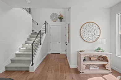 Foyer entrance with stairway and light wood-style floors