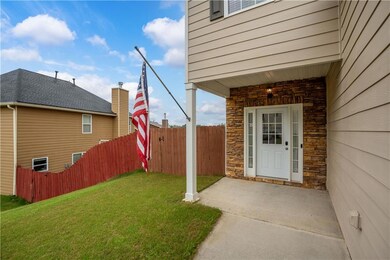 Entrance to property with stone siding and a patio