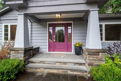 Beautiful stonework and landscaping adorns the covered front patio.