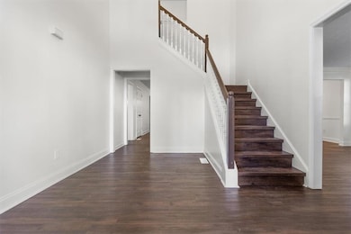 Staircase with wood finished floors and a high ceiling