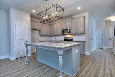Kitchen with pendant lighting, gray cabinetry, a k