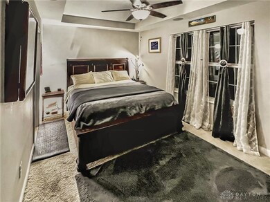 Primary bedroom with trey ceiling & fan