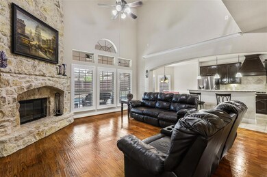 Spacious living area featuring the stone fireplace and high ceilings.