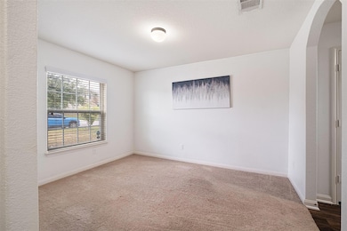 Unfurnished room with carpet and arched walkways