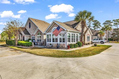 View of front of house with stone siding, driveway