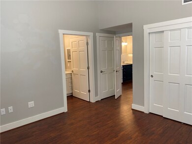 Bedroom with dark wood finished floors, baseboards