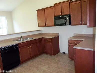 Kitchen. Large, open kitchen has abundant cabinetry, Whirlpool appliance package, dramatic cathedral ceiling and long bar top.  Range included but not installed yet.