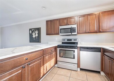 Kitchen with ornamental molding, light tile patter