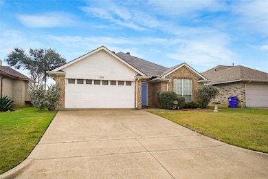 Single story home with a front lawn, brick siding, driveway, and a garage