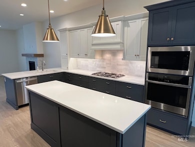 Kitchen featuring light wood-style flooring, stainless steel appliances, tasteful backsplash, a peninsula, and recessed lighting