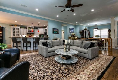 LED lighting and crown molding shine down on spacious living area.
