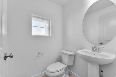 Half bath with baseboards and toilet