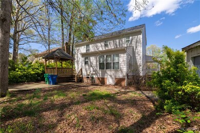 Back of property featuring a gazebo, a deck, and c