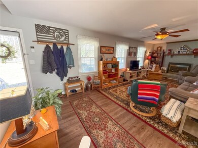 Living area with a fireplace, a ceiling fan, and w