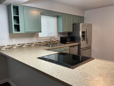 Kitchen featuring appliances with stainless steel finishes, decorative backsplash, and light countertops