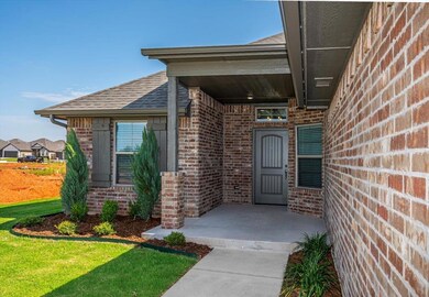 Property entrance with brick siding, roof with shingles, and a yard