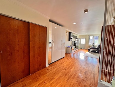 Entryway featuring light wood-type flooring and ornamental molding