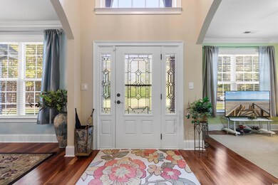 Foyer with crown molding, a wealth of natural ligh