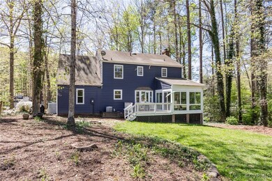 Back of property featuring a chimney, a lawn, a wo
