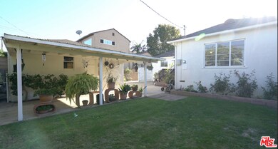 Backyard with grassy area & covered patio area off garage