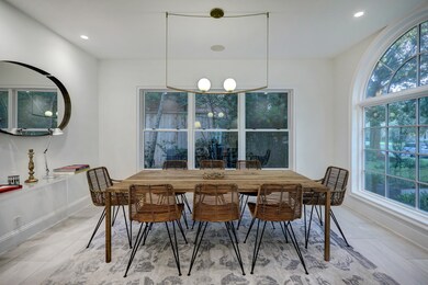 Plan your next dinner party for eight or more under a contemporary brass and milk glass chandelier in the delightful dining room.
