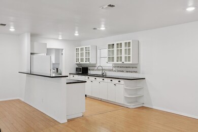 Kitchen with freestanding refrigerator, light woo