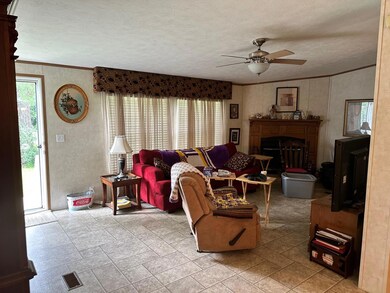 Living room featuring tile floors, ceiling fan, a 