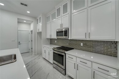 Kitchen featuring visible vents, marble finish floor, appliances with stainless steel finishes, and white cabinets