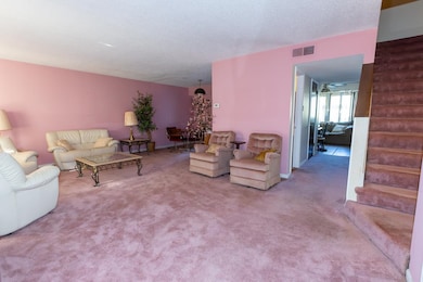 Carpeted living room featuring a textured ceiling