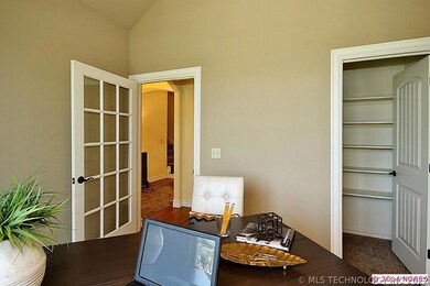Office with walk in closet and large paned window.