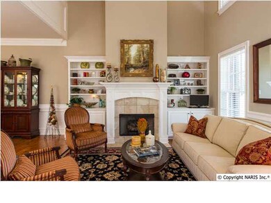 The living room boasts extensive molding, hardwoods, a gas log fireplace and soaring ceilings for spaciousness.