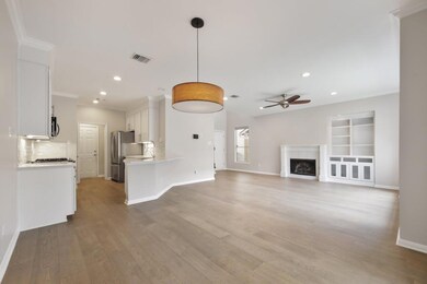Unfurnished living room with ornamental molding, light wood finished floors, a tiled fireplace, a ceiling fan, and recessed lighting